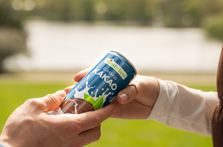 Kakaomilchdose wird überreicht mit See im Hintergrund